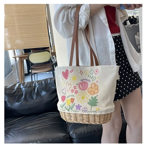 Dettaglio della borsa tote in tela con fondo in rattan, stampa floreale e manici in pelle