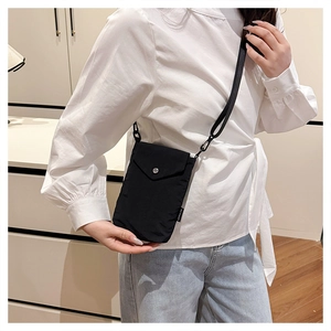 Dettaglio mini borsa a tracolla in nylon nero con fibbia in metallo argentato lucido