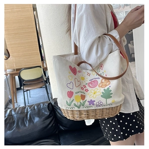 Dettaglio della borsa tote in tela e rattan con graffiti artistici e manici in pelle