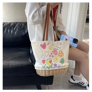 Dettaglio della borsa tote in tela e paglia con stampe colorate e manici in pelle