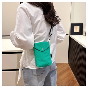 Vista posteriore di una modella con mini borsa per cellulare in nylon verde brillante