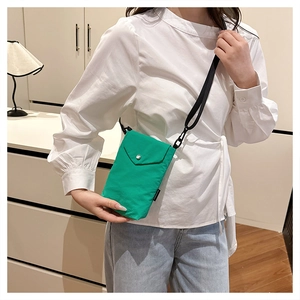 Dettaglio della mini borsa a tracolla in nylon verde brillante con chiusura a scatto