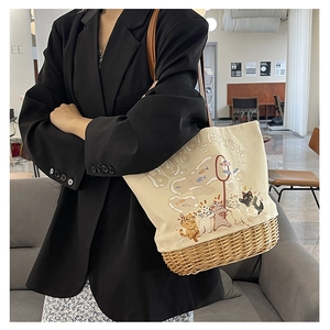 Vista dettagliata di una borsa tote in tela e vimini con stampa di gatto su una modella