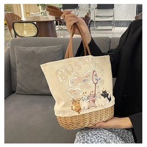 Dettaglio borsa tote in tela e rattan con illustrazione di gatto e manici in pelle