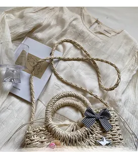 Détail du sac de plage tissé avec nœud noir et blanc, étoile et doublure à cordon