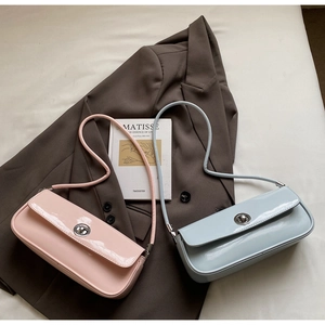 Nahaufnahme von pastellrosa und blauen Baguette-Taschen aus Lackleder mit Metalldrehschloss