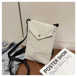 Dettaglio della borsa porta cellulare in nylon beige con patta e targhetta