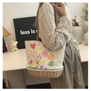 Dettaglio della borsa tote in tela stampata con base in paglia e manici in pelle marrone