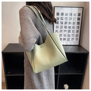 Detail of mint green tote bag featuring wavy cut edges and vertical stitching accents