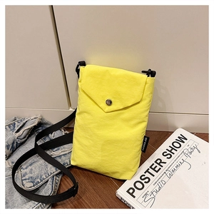 Dettaglio di una borsa a tracolla in nylon giallo con fibbia in metallo e cinturino