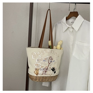 Dettaglio della borsa tote in tela stampata con base intrecciata e illustrazioni di gatti