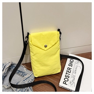 Dettaglio mini borsa a tracolla in nylon giallo acceso con bottone a pressione e tracolla