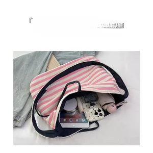 Detail of spacious interior layout in pink striped tote bag with tablet and accessories