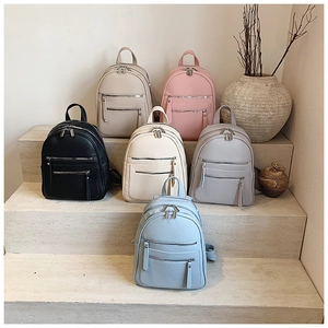 Detailed view of fashionable leather backpacks in multiple colors on stone stairs