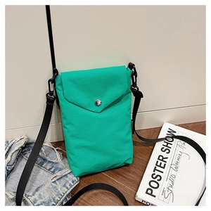 Vista dettagliata di una mini borsa a tracolla in nylon verde con fibbia metallica