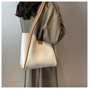 Detailed close-up of a two-tone bucket tote bag with cream leather and brown straps