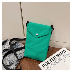 Dettaglio della borsa a tracolla in nylon verde con bottone argento e cinturino