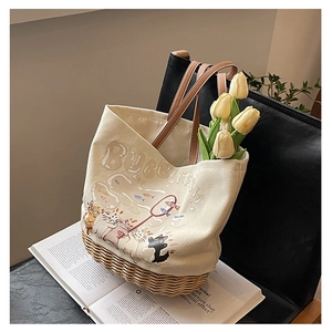 Dettaglio borsa tote in tela con base in rattan, stampa di gatto e tulipani gialli