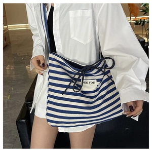 Detail of blue and white striped canvas tote with black bow and See You patch