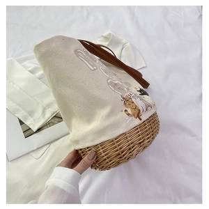 Dettaglio della base in rattan intrecciato e tessuto canvas con stampa di gatto sulla borsa