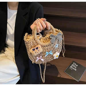 Détail du sac en paille tissé à la main avec ours mignon, rubans et anses rondes