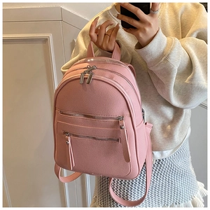 Pink pebbled leather backpack detail with multiple zippered compartments and silver hardware
