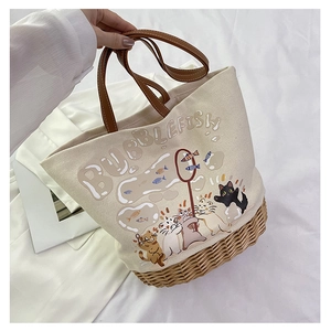 Dettaglio della borsa tote in tela con stampa gatto carino e base in vimini intrecciato