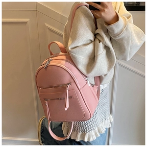 Detailed view of pink mini backpack featuring premium litchi grain texture and silver zippers