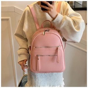 Pink pebbled leather backpack shown in a mirror selfie for size and styling reference