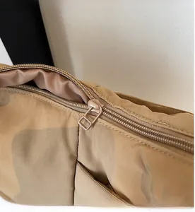 Close-up of smooth matte metal zipper and durable khaki camo nylon fabric texture