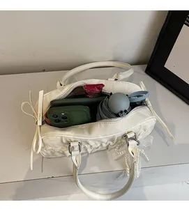 Detail view of large capacity interior for off-white pleated shoulder bag with lace charm