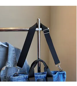 Détail du sac cabas en denim bleu avec bandoulière réglable en nylon noir et crochets