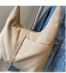 Detail of soft nylon beige tote bag with functional exterior pocket and zipper