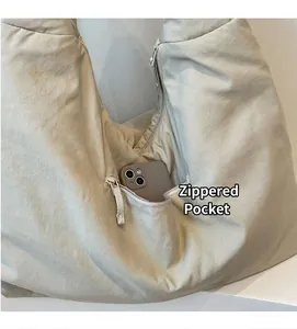 Dettaglio della borsa tote in nylon con tasca laterale a zip per riporre lo smartphone