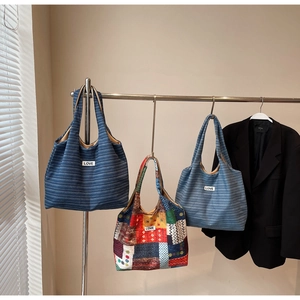Drie bohemian canvas shoppers met LOVE-patches aan een minimalistisch metalen rek