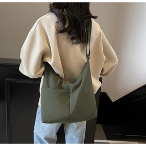 Detail of adjustable wide shoulder strap on an olive green nylon hobo shoulder bag