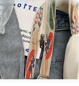 Close-up of colorful jacquard woven strap with a smooth silver zipper on the chest bag