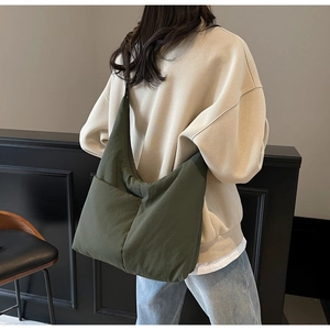 Deep green nylon tote bag with zipper and large capacity shown on model for daily use