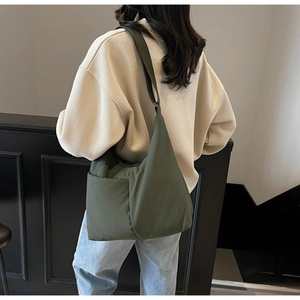 Rear view of an olive green oversized hobo bag showing crossbody fit and drape