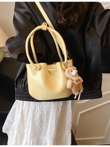 Light yellow pleated bucket bag with adjustable strap and cute plush bear pendant charm