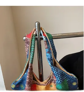 Detailopname van een kleurrijke patchwork canvas draagtas met bloemenprints en handgrepen