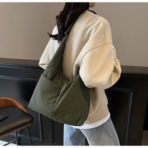 Detailed view of the dark green quilted nylon fabric on a soft puffer tote bag