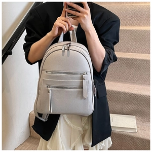 Close-up of litchi grain leather texture and zipper detail on casual women's backpack