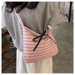 Detail of pink and white striped canvas tote bag with a dark blue bow decoration