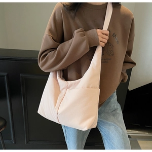 Light pink nylon tote bag shown on shoulder, highlighting spacious casual design