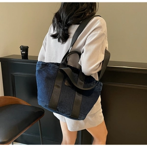 Vue détaillée d'un sac cabas en denim foncé avec patch cuir et anses nylon