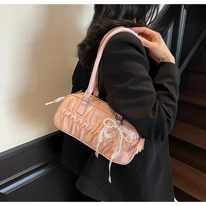 Detail of pink pleated bowling bag featuring a lace bow and pearl bead accessory