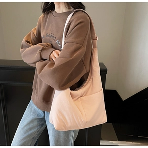 Minimalist light pink nylon tote bag showing adjustable shoulder strap details