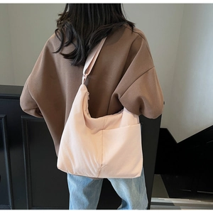 Close-up of pink nylon tote bag showing its large capacity and soft crescent shape design