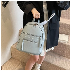 Light blue lychee pattern leather backpack with triple zipper compartments shown on model